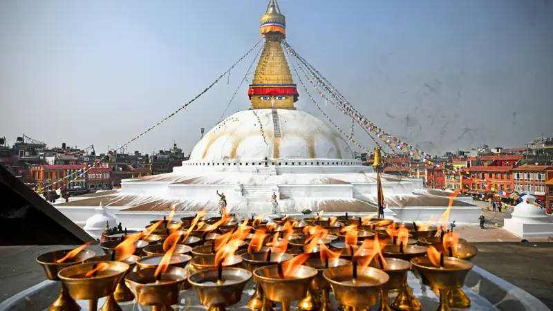 Lo stupa bianco di Boudhanath con lumini votivi in primo piano