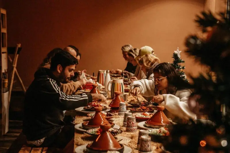 Un gruppo cena insieme attorno a una tavola con tajine