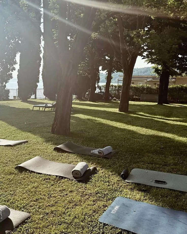 Tappetini da yoga stesi sull'erba tra gli alberi
